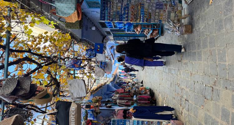 Turistas caminando por un animado callejón de mercado.