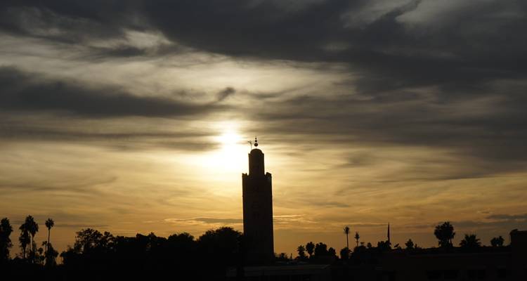 Silueta de una torre durante una puesta de sol dramática.