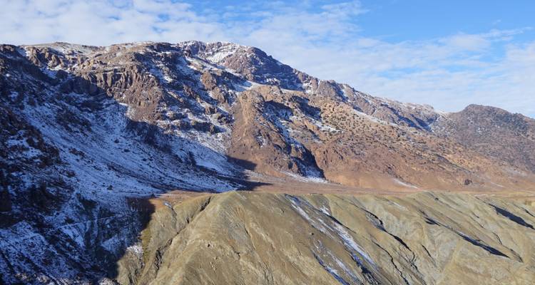 Cordillera nevada bajo un cielo azul.