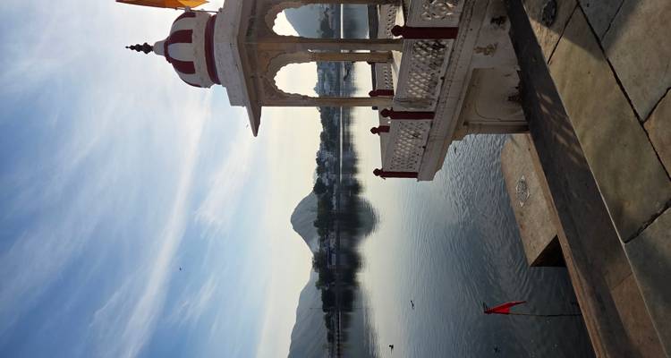 Pavillon au bord du lac avec des collines en arrière-plan.