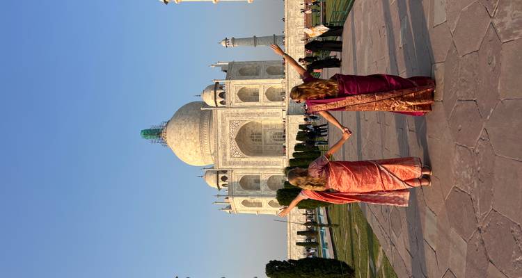 Deux personnes en vêtements traditionnels devant le Taj Mahal.