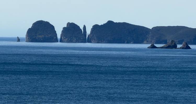 Eilandjes zichtbaar over de oceaan vanaf de kust.