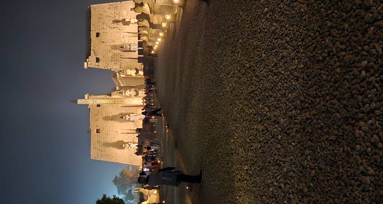 The entrance to Luxor Temple illuminated at night with visitors exploring.