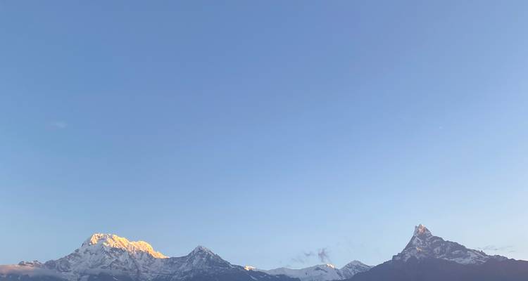 Vue dégagée des sommets montagneux au lever du soleil.