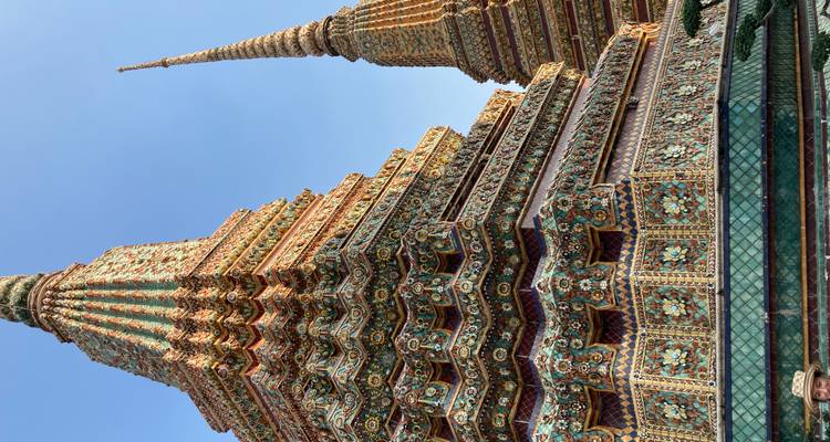Stupas décorés de manière complexe contre un ciel bleu clair.