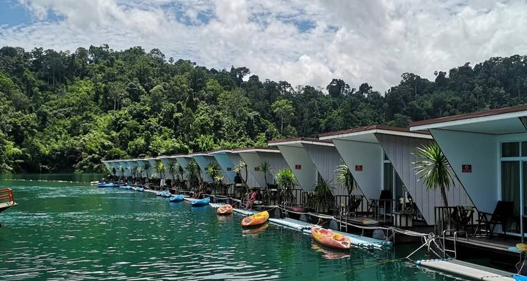 Rangée d'hébergements de villégiature flottants sur un lac vert.