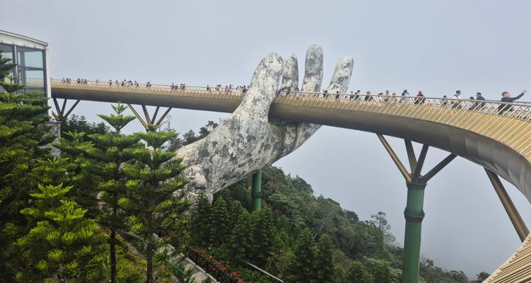 Puente Dorado con manos gigantes en Vietnam con turistas caminando.