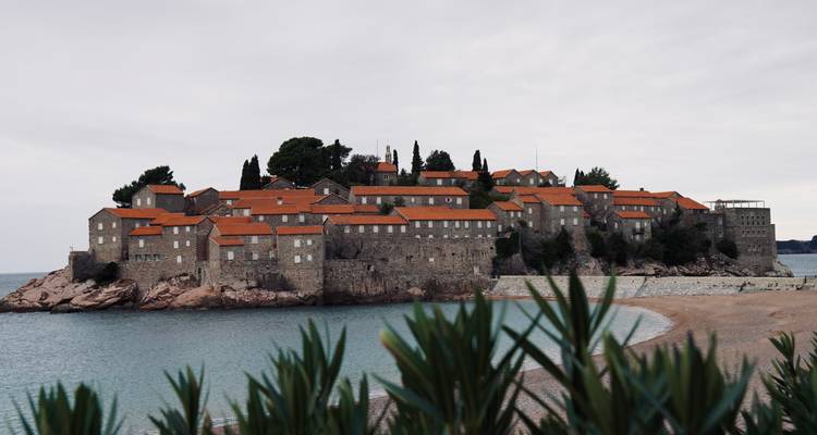 Île avec des bâtiments en pierre et des toits rouges sur la côte adriatique.