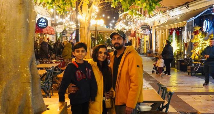 Famille posant dans une rue animée avec des décorations et des cafés.