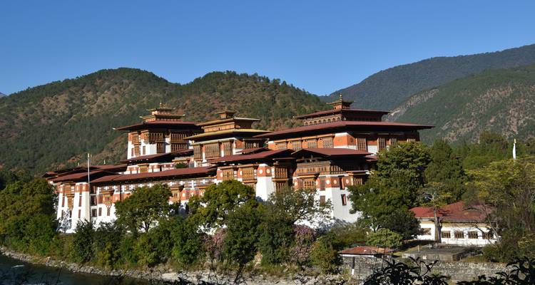 Der Punakha Dzong, eine majestätische Festung an einem Flussufer mit Bergkulisse.