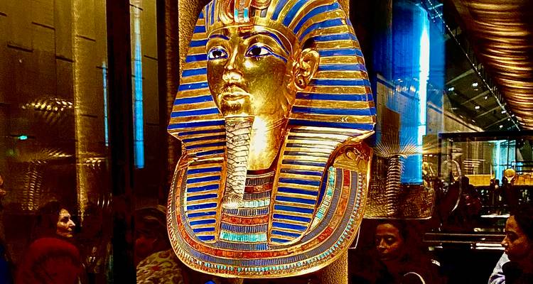 Masque en or exposé dans un cadre muséal.