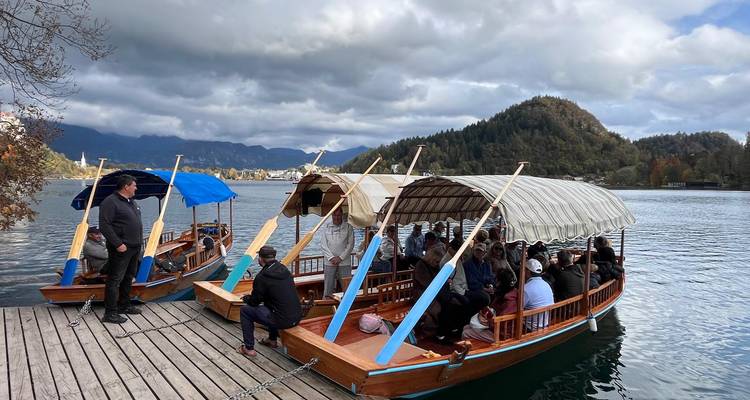 Turistas en botes tradicionales de madera en un lago.
