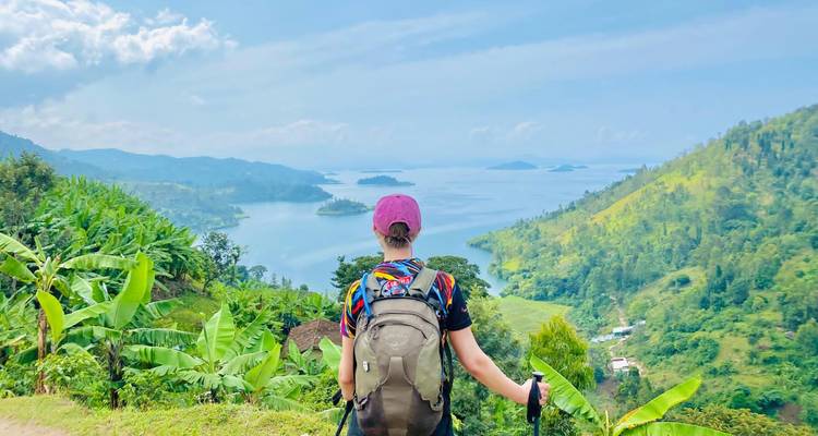 Personne avec un sac à dos surplombant un lac au Rwanda.