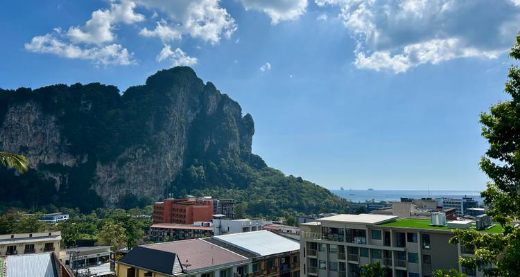 Bâtiments modernes avec une montagne en arrière-plan et vue sur la mer.