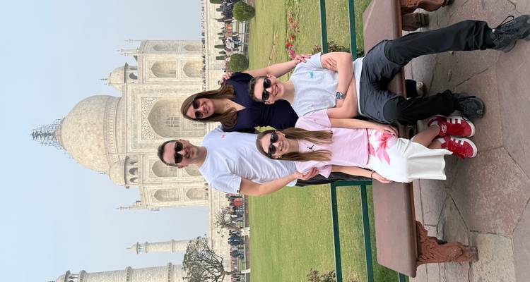 Familia posando frente al Taj Mahal, un famoso monumento arquitectónico.