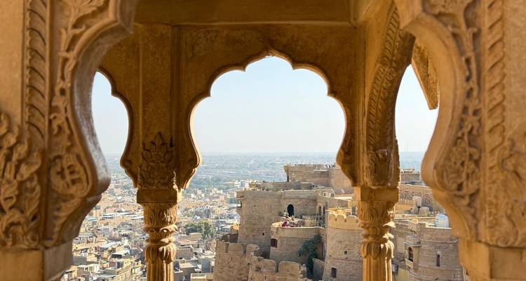 Vista panorámica a través de arcos ornamentados con vista a una fortaleza antigua.