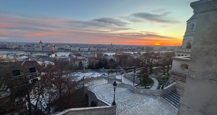 Vista del paisaje urbano con río y atardecer distante.