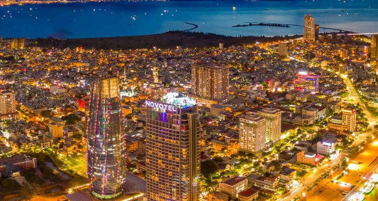 Paisaje urbano nocturno con edificios iluminados y río