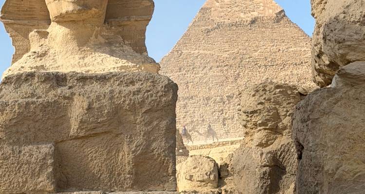 View of the Sphinx and one of the pyramids with desert setting.