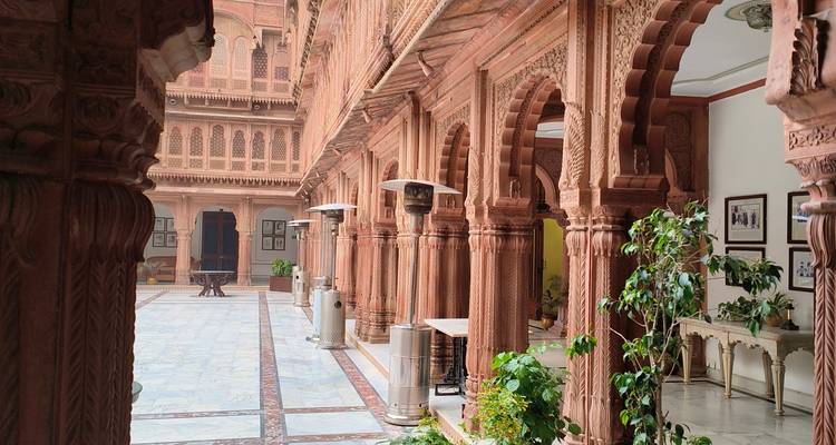 Patio de piedra intrincadamente tallado con arcos y columnas.