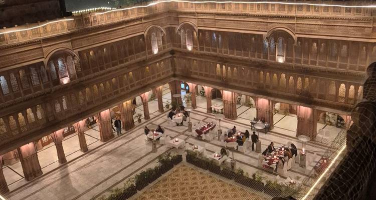 Vista interior de un patio con mesas dispuestas para cenar.