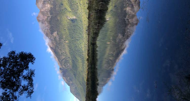 Montañas reflejándose en la superficie de un lago cristalino.