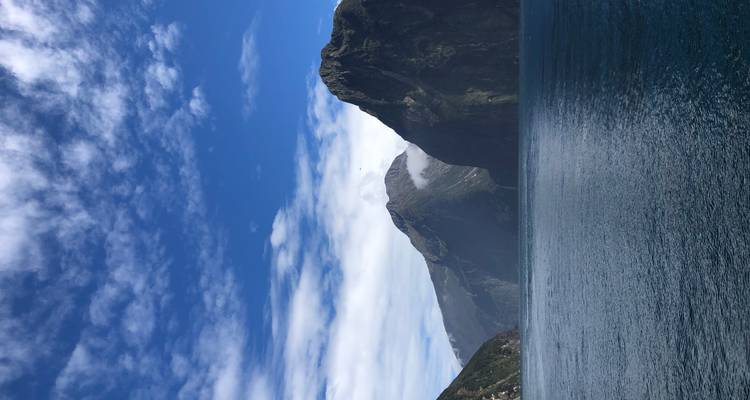 Cadena montañosa con entrada de mar bajo un cielo azul despejado.