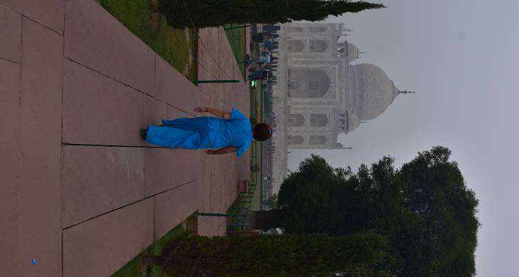Frau, die in einer ruhigen Umgebung auf das Taj Mahal zugeht.