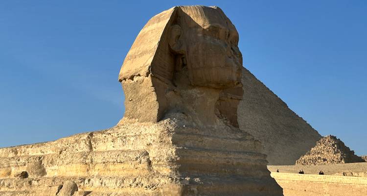 Le Sphinx avec les pyramides en arrière-plan sous un ciel dégagé.