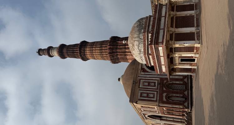 Complejo Qutub Minar con un minarete antiguo y edificios circundantes.