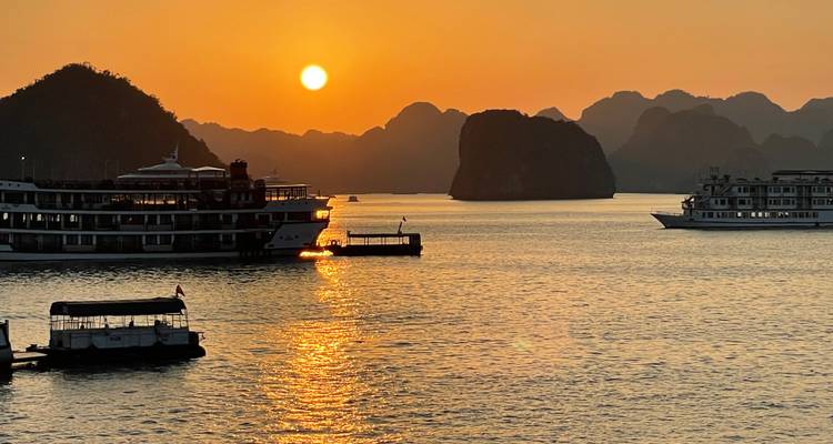Coucher de soleil sur l'eau avec des navires de croisière.