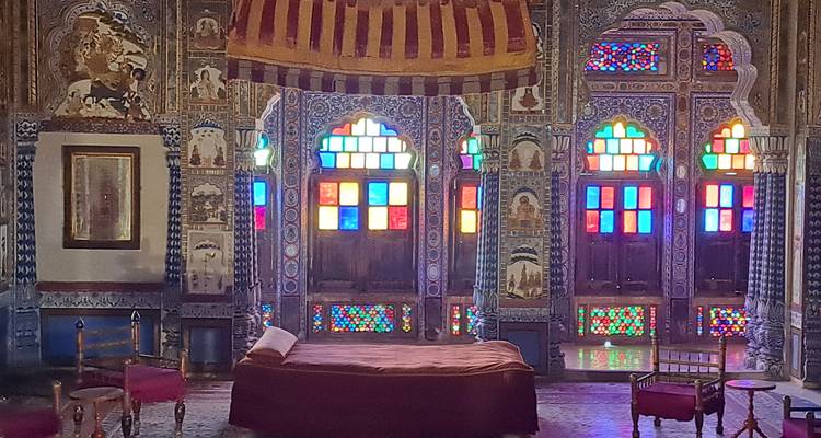 Pièce avec des vitraux colorés et une décoration ornée.