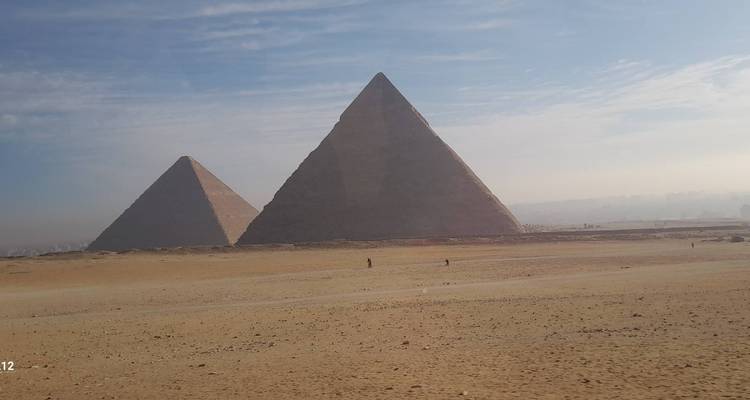 Deux pyramides dans le désert avec un ciel brumeux.