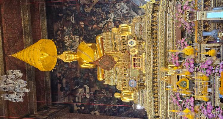 Buda dorado sentado en un templo ricamente decorado.