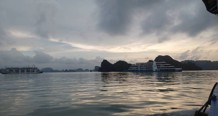 Vista panorámica de la Bahía de Halong con cruceros al atardecer.