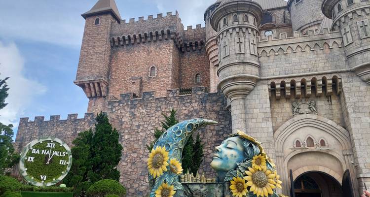 Estructura similar a un castillo con una estatua decorativa y el reloj de Ba Na Hills.