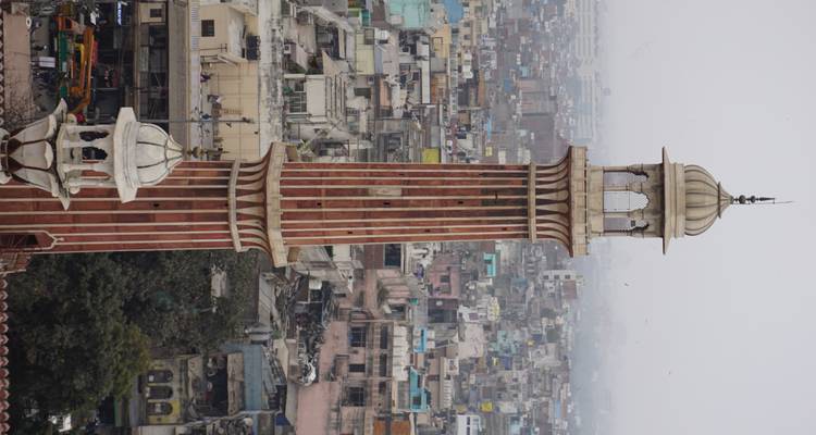 Grand minaret avec un paysage urbain en arrière-plan.