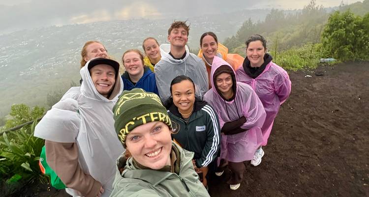 Grupo de personas posando en una montaña con equipo para la lluvia.