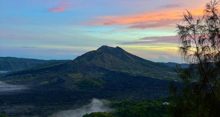 Paisaje montañoso con cielos dramáticos al atardecer.