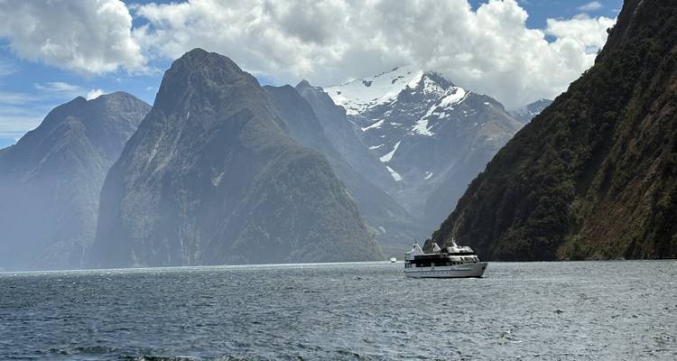 Vue panoramique de Milford Sound avec un bateau et des montagnes.