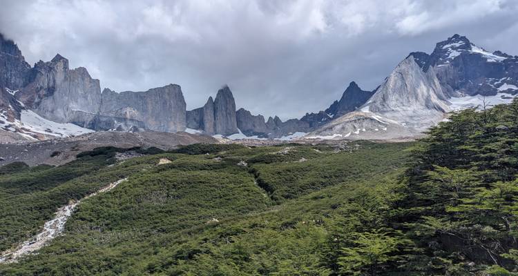 Vista expansiva de cordillera montañosa con picos cubiertos de nieve.