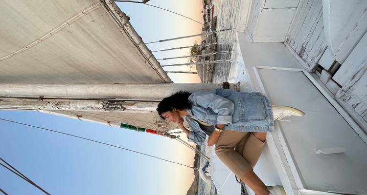 Femme assise sur un voilier avec des vues panoramiques.