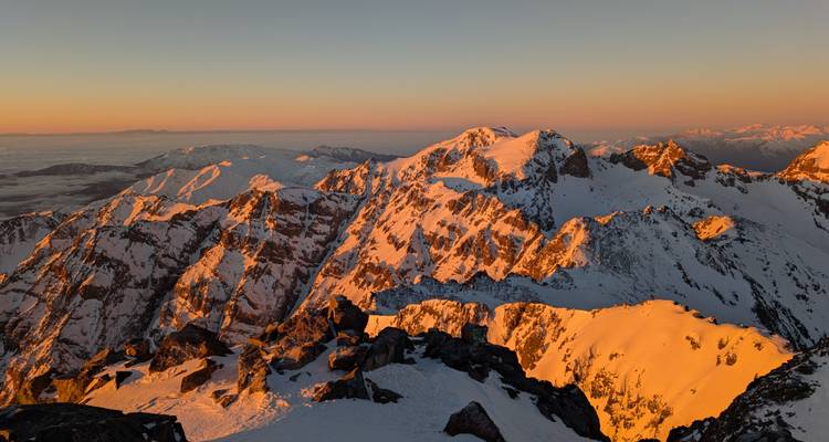 Sommets de montagnes enneigés au lever du soleil.