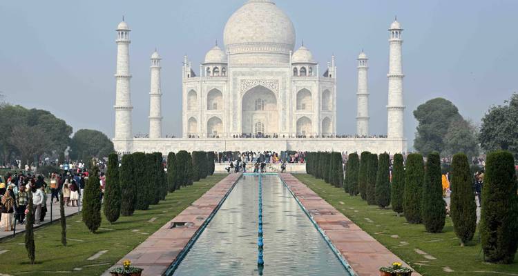 El Taj Mahal con un estanque reflectante y turistas.