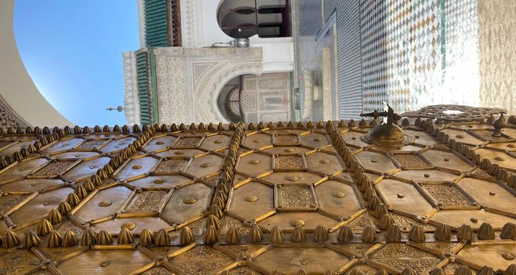 Porte en bois ornée s'ouvrant sur une cour au Maroc.