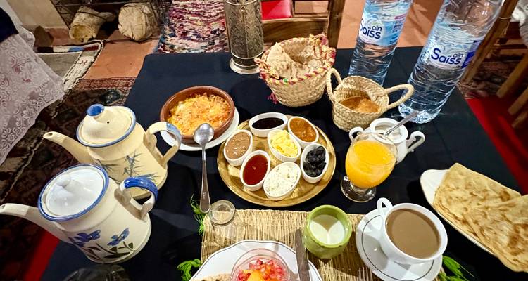 Configuration de petit-déjeuner marocain traditionnel avec divers plats.