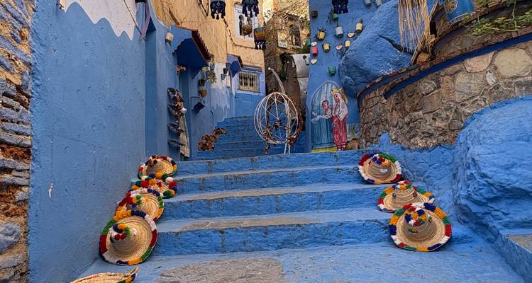 Marches peintes en bleu avec des chapeaux traditionnels à Chefchaouen.