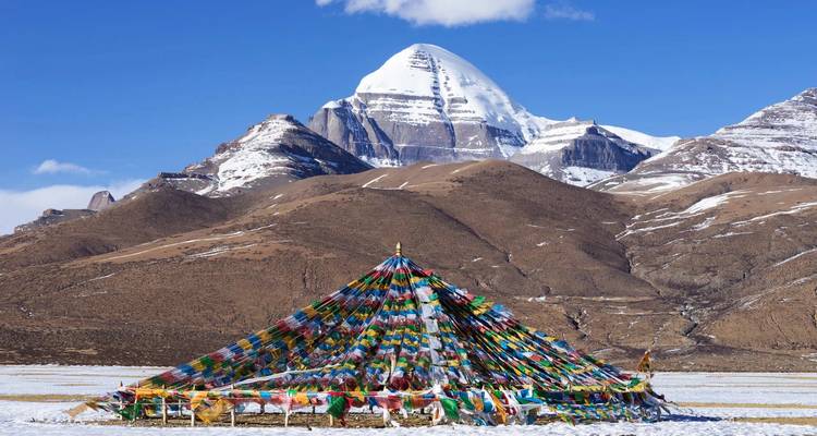 Monte Kailash cubierto de nieve con banderas de oración coloridas en primer plano.