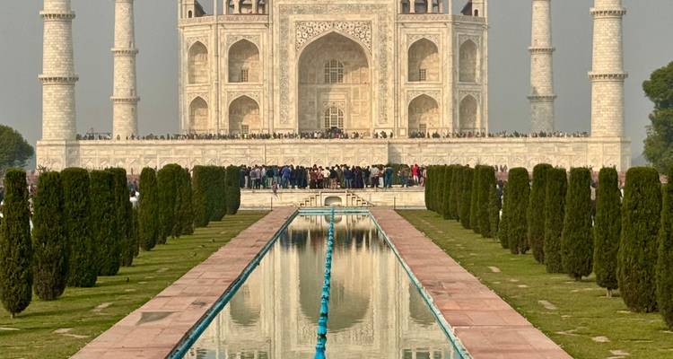 Le Taj Mahal avec des gens devant et son reflet dans l'eau.