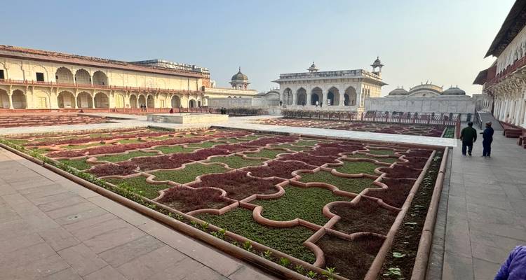 Une vue de structures architecturales avec des jardins et des gens qui marchent.